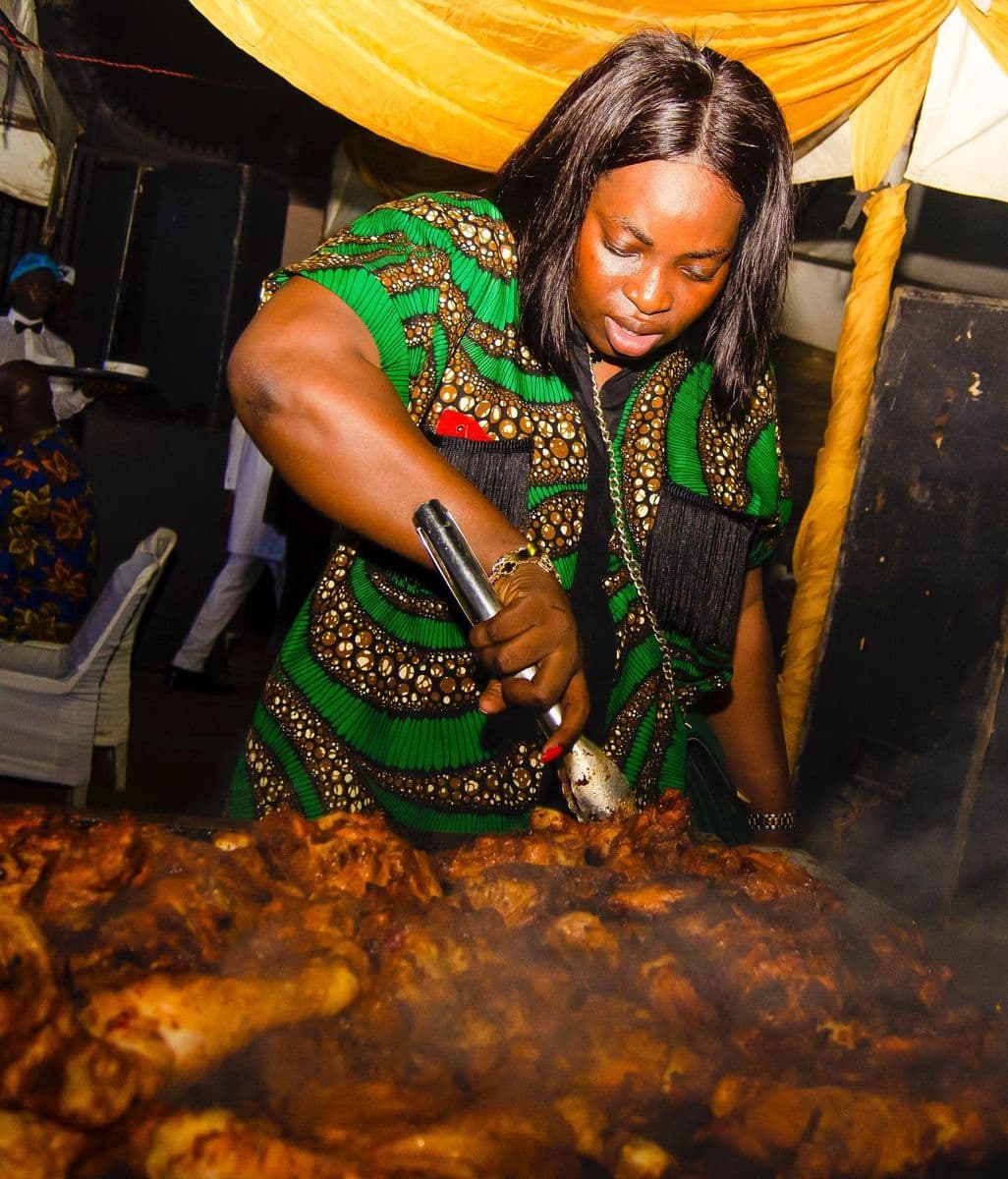 Miss Kofoworola Laguda, CEO and MD of KAF Eatables, turning grilled chicken with tongs at a live event