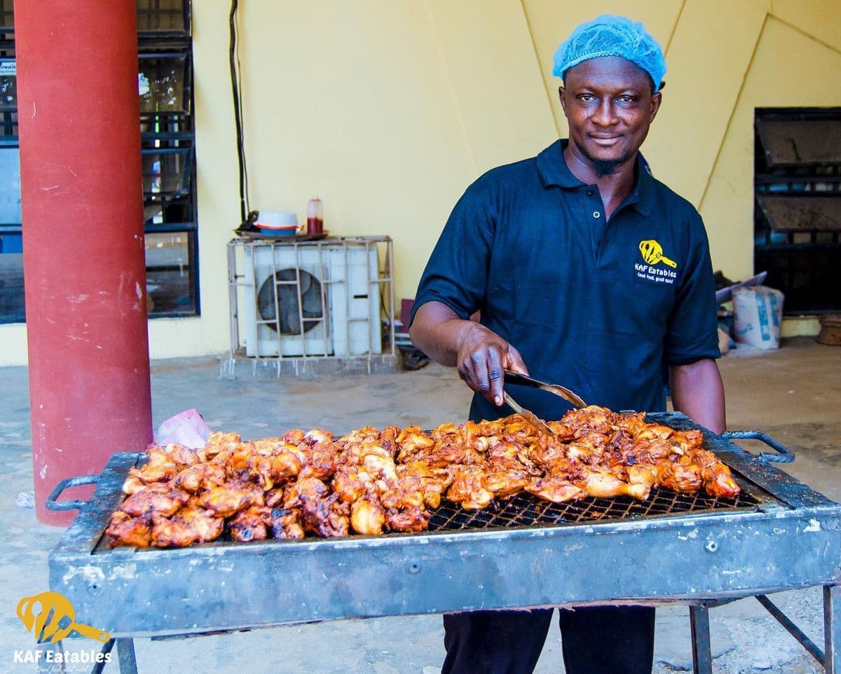 KAF Eatables chef grilling chicken on a charcoal grill at an event