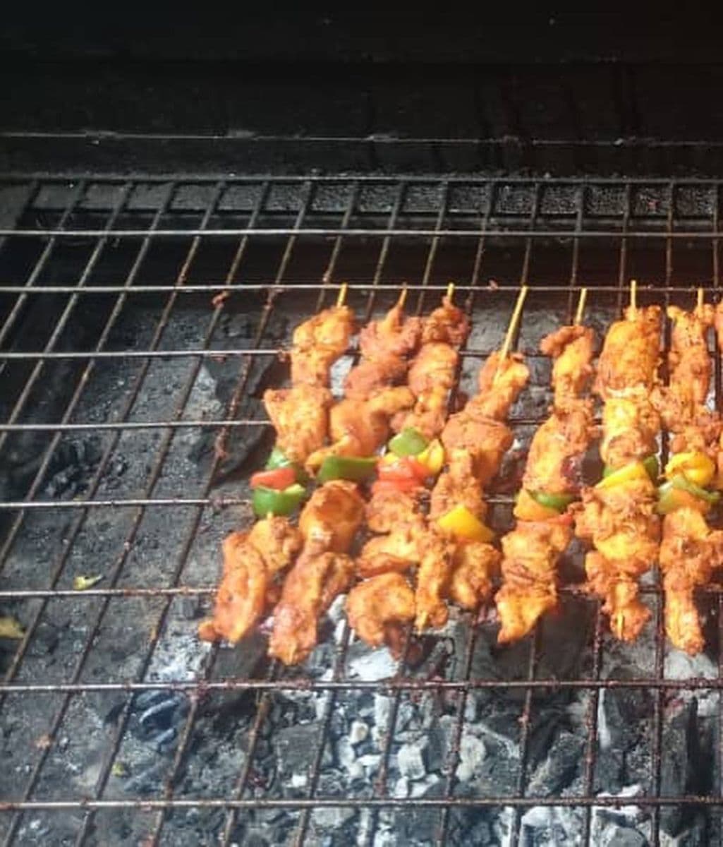 KAF Eatables chicken kebab skewers cooking on a charcoal grill